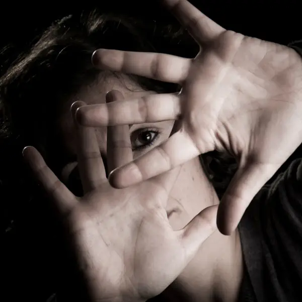 mujer tapando su cara con las manos abiertas